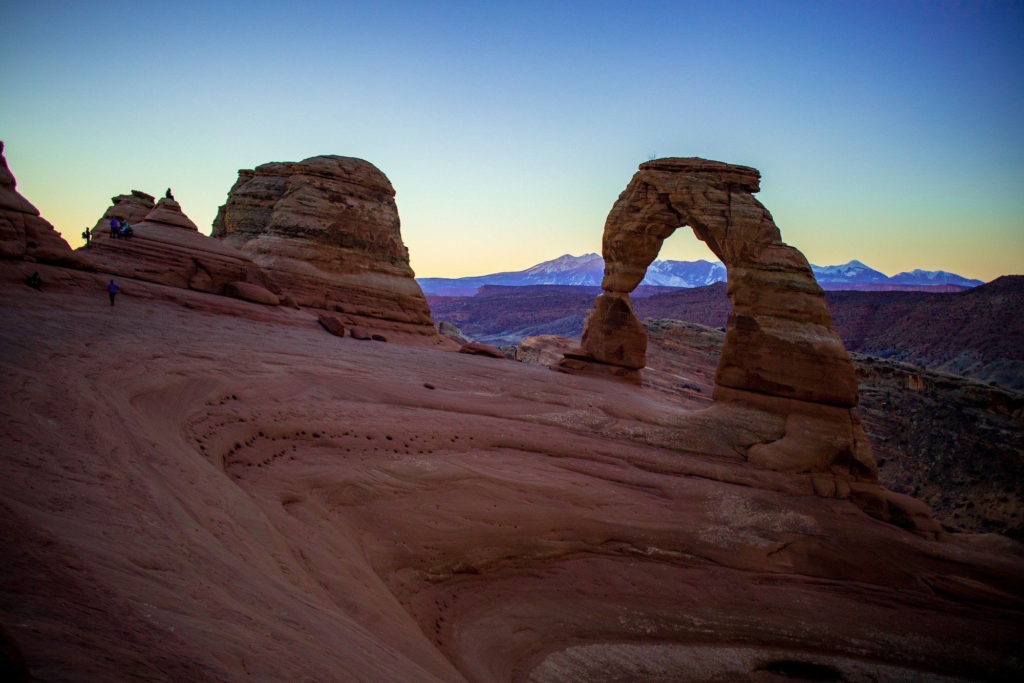 Delicate arch with the first rays of sunrise hitting the La Sal mountains behind.