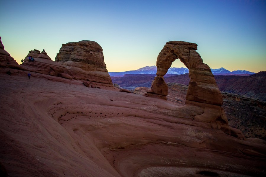 Delicate arch with the first rays of sunrise hitting the La Sal mountains behind.